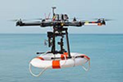 A drone carrying a lifebuoy, flying over water.